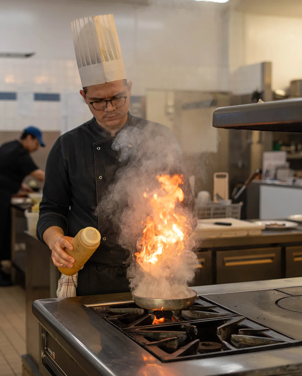 Clément Piedfert - Second de cuisine Clément Piedfert, second de cuisine de La Couronne, en pleine préparation d'un plat flambé à Rouen
